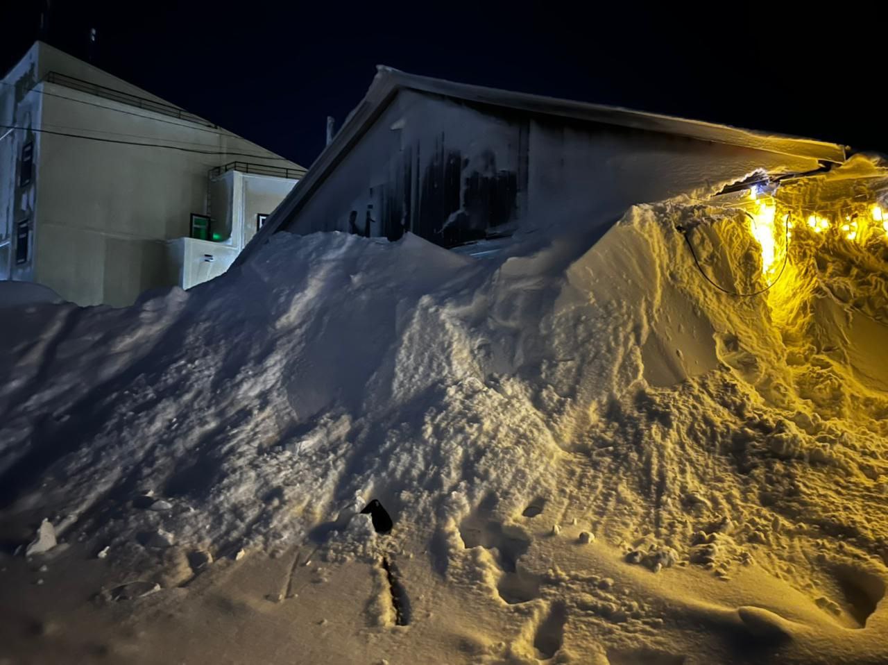 Снегом укрыты дома. Много снега. Снежный дом. Снег ночью. Дом замело снегом.