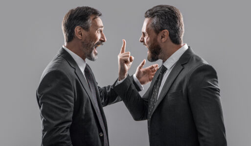 arguing businessmen shouting. photo of businessmen arguing with anger. two arguing businessmen isolated on grey background. businessmen arguing in studio.
спор