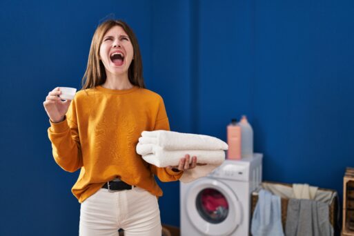 Young brunette woman holding detergent and clean laundry angry and mad screaming frustrated and furious, shouting with anger looking up.
Стиральная машина