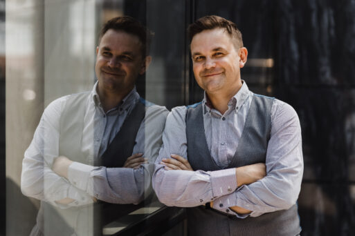 Handsome man smiling in sunlight. Man on cityscape and buildings with reflections of city. Businessman in vest
Высокомерный коллега