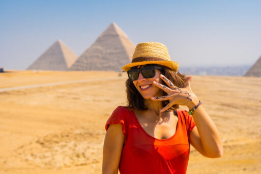 Portrait of a young tourist in red dress enjoying the pyramids of Giza, the oldest funerary monument in the world. In the city of Cairo, Egypt
египет девушка в красном платье на экскурсии