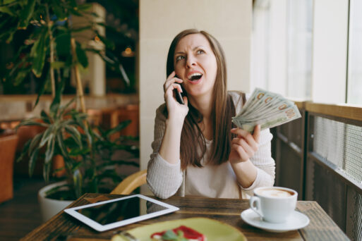 Woman in coffee shop at table with bundle of dollars, cash money, mobile phone, cup of cappuccino, cake, relaxing in restaurant during free time. Female working on pc tablet computer rest in cafe
финансы календарь луна